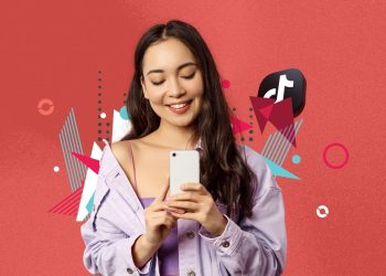 A TikTok creator dancing on an autumn-colored street with a phone tripod.